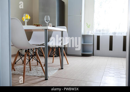 Dinner setting for two served in kitchen. Modern kitchen design. Roasted meat with wine prepared in dining room. Stock Photo