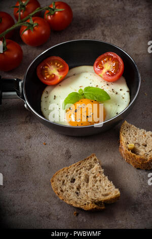 One egg in a little pan with cherry tomatoes and bread Stock Photo