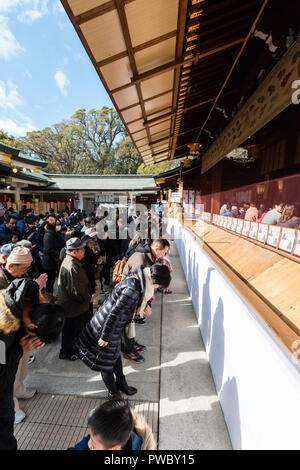 Japanese new year, shogatsu. People standing and praying at the scared area in the main hall, Honden of the Nishinomiya Shinto shrine. Stock Photo