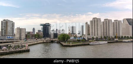 View to the modern innovative city center with tall tall impressive skyscrapers, marine memorial 'The Bow' and ships on Nieuwe Maas river. Stock Photo