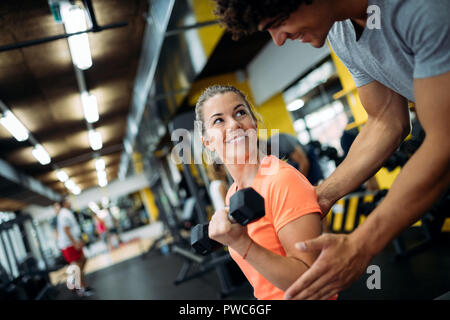 Young beautiful woman doing exercises with personal trainer Stock Photo