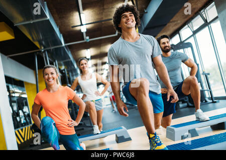 Group of young people doing exercises in gym Stock Photo