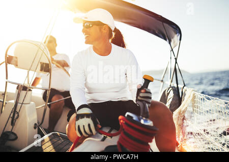 Attractive strong woman sailing with her boat Stock Photo