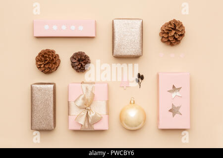 Pastel pink and gold minimal christmas background. Beautiful nordic christmas gifts isolated on beige background. Pink colored wrapped xmas boxes comp Stock Photo