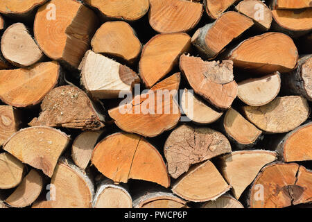 A pile of stacked firewood, prepared for heating the house. Chopped firewood on a stack. Stock Photo