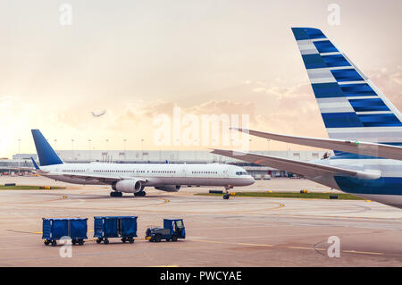 Two airplanes on tarmac with cargo at airport Stock Photo