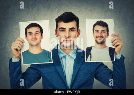 Young man holding two portrait photo sheets with different character. Change your personality, fake mask to hide the real expression of yourself. Stock Photo
