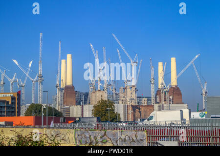 White tower cranes surround the iconic decommissioned Battersea Power Station being redeveloped for mixed uses and high class luxury apartments Stock Photo