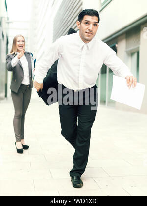 Man is running away from angry businesswoman because she is dissatisfied of the results of the financial report outdoors. Stock Photo