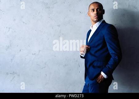 Cool african businessman standing on grey background. Stock Photo