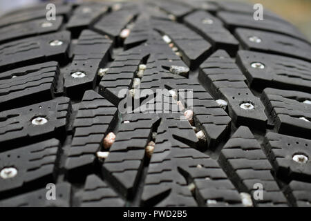Used snow tire with metal studs close up. Horizontal background image. Stock Photo