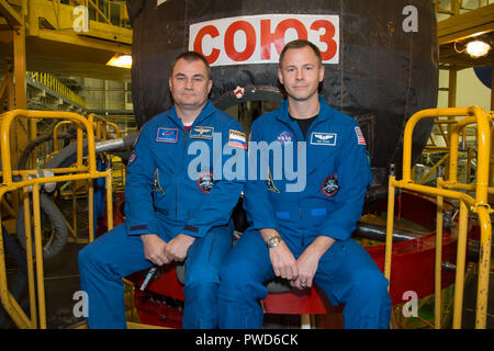 Expedition 57 crew member cosmonaut Alexey Ovchinin of Roscosmos, left, and Nick Hague of NASA pose in front of the Soyuz MS-10 spacecraft in their blue flight suits at the Baikonur Cosmodrome September 26, 2018 in Baikonur, Kazakhstan. The two are scheduled to launch on October 11th and will spend the next six months living and working aboard the International Space Station. Stock Photo