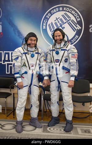 Expedition 57 crew member cosmonaut Alexey Ovchinin of Roscosmos, left, and Nick Hague of NASA pose in their Sokol launch and entry suits at the Baikonur Cosmodrome September 26, 2018 in Baikonur, Kazakhstan. The two are scheduled to launch on October 11th and will spend the next six months living and working aboard the International Space Station. Stock Photo