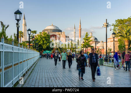 Hagia Sophia museum with tourists walking in the Blue Archaeological Park in late afternoon light, Istanbul Stock Photo