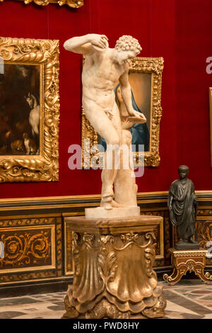The sculpture Dancing Faun on a golden pedastal in the Tribuna room in the Uffizi Gallery in Florence, Italy. Stock Photo