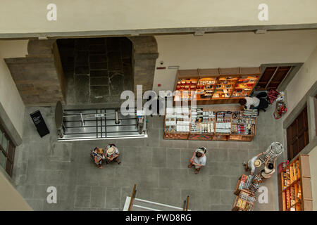 A cafe inside the Uffizi from above with tourists browsing the products on sale. Stock Photo