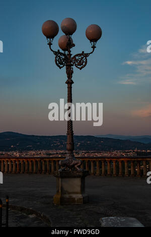 A streetlight still not on just before full sunset on Piazzale Michelangelo in Florence, Italy. Stock Photo