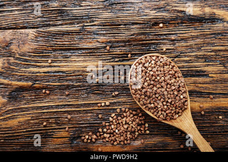 raw buckwheat on the table in a wooden spoon. place for text Stock Photo