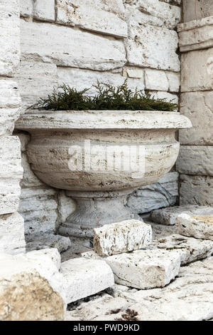 An ancient stone Greek vase against the wall. ancient greek ruins Stock Photo