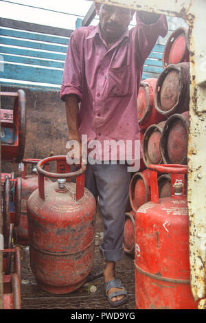 Worker delivering LPG gas cylinders into the truck for customers Stock Photo