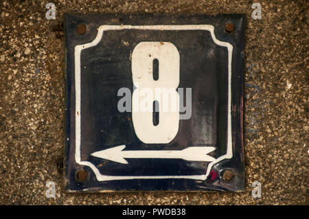 Weathered grunge square metal enameled plate of number of street address with number 8 closeup Stock Photo