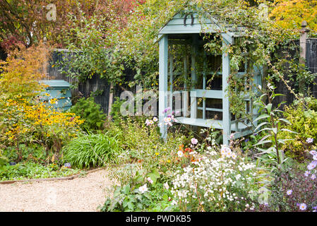 Gravel path leading to an empty garden bench Stock Photo