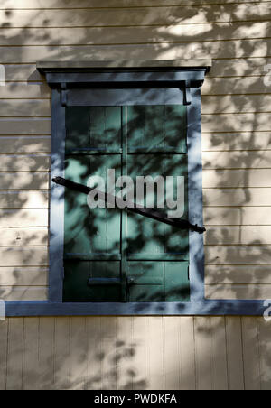 A closed hatch on a wooden wall in daylight Stock Photo