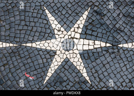 Classic black and white shiny cobblestones set in symmetric star design shapes in street in central Lisbon Portugal Stock Photo