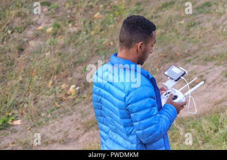 Man in blue jacket operating a drone Stock Photo