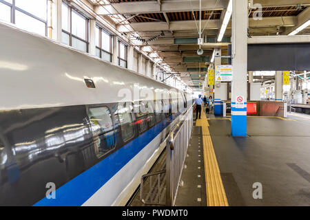 Osaka, JP - JUNE 28, 2017: Gates of Shinkansen high-speed bullet train opening at station for passengers, viewing form railway side, shown as abstract Stock Photo