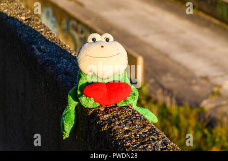 Frog puppet with a read heart, abandoned in Vilnius, Lithuania, at sunset Stock Photo