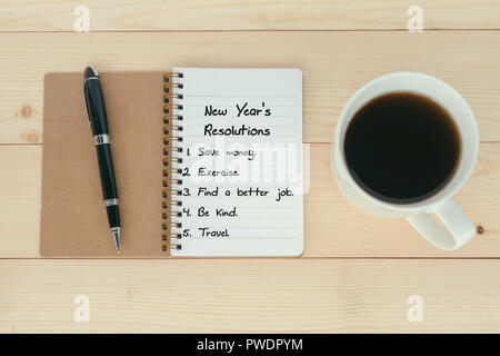 New Year's Resolutions list on notepad with pen and cup of coffee Stock Photo