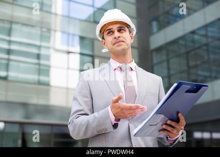 Businessman holding folder with documents and attentively reading Stock Photo