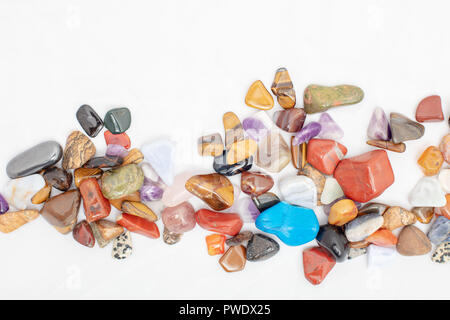Bunch of colorful stones scattered against white background Stock Photo