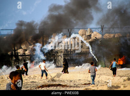 October 15, 2018 - Dozens of Palestinian protesters are injured during clashes with the Israeli army on a beach in northwestern Gaza, close to the border with Israel, on 15th October 2018. Injured protesters were rescued by paramedics after being hit by Israeli live gunfire and being asphyxiated by tear gas. Hundreds of demonstrators had gathered on the beach near Beit Lahiya to demand the lift of the Israeli blockade on Gaza, which Israel has imposed since 2007, as Hamas took over power in the Strip, and which has been strangling the Palestinian enclave and causing a humanitarian crisis for t Stock Photo