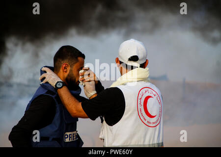 October 15, 2018 - Dozens of Palestinian protesters are injured during clashes with the Israeli army on a beach in northwestern Gaza, close to the border with Israel, on 15th October 2018. Injured protesters were rescued by paramedics after being hit by Israeli live gunfire and being asphyxiated by tear gas. Hundreds of demonstrators had gathered on the beach near Beit Lahiya to demand the lift of the Israeli blockade on Gaza, which Israel has imposed since 2007, as Hamas took over power in the Strip, and which has been strangling the Palestinian enclave and causing a humanitarian crisis for t Stock Photo