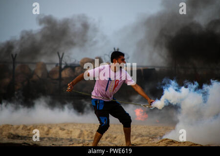 October 15, 2018 - Dozens of Palestinian protesters are injured during clashes with the Israeli army on a beach in northwestern Gaza, close to the border with Israel, on 15th October 2018. Injured protesters were rescued by paramedics after being hit by Israeli live gunfire and being asphyxiated by tear gas. Hundreds of demonstrators had gathered on the beach near Beit Lahiya to demand the lift of the Israeli blockade on Gaza, which Israel has imposed since 2007, as Hamas took over power in the Strip, and which has been strangling the Palestinian enclave and causing a humanitarian crisis for t Stock Photo