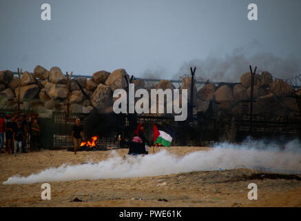 October 15, 2018 - Dozens of Palestinian protesters are injured during clashes with the Israeli army on a beach in northwestern Gaza, close to the border with Israel, on 15th October 2018. Injured protesters were rescued by paramedics after being hit by Israeli live gunfire and being asphyxiated by tear gas. Hundreds of demonstrators had gathered on the beach near Beit Lahiya to demand the lift of the Israeli blockade on Gaza, which Israel has imposed since 2007, as Hamas took over power in the Strip, and which has been strangling the Palestinian enclave and causing a humanitarian crisis for t Stock Photo