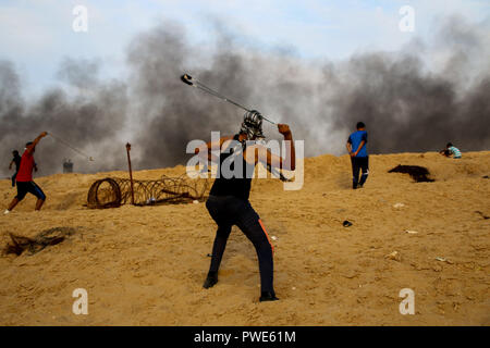 October 15, 2018 - Dozens of Palestinian protesters are injured during clashes with the Israeli army on a beach in northwestern Gaza, close to the border with Israel, on 15th October 2018. Injured protesters were rescued by paramedics after being hit by Israeli live gunfire and being asphyxiated by tear gas. Hundreds of demonstrators had gathered on the beach near Beit Lahiya to demand the lift of the Israeli blockade on Gaza, which Israel has imposed since 2007, as Hamas took over power in the Strip, and which has been strangling the Palestinian enclave and causing a humanitarian crisis for t Stock Photo