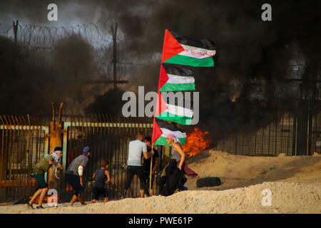 October 15, 2018 - Dozens of Palestinian protesters are injured during clashes with the Israeli army on a beach in northwestern Gaza, close to the border with Israel, on 15th October 2018. Injured protesters were rescued by paramedics after being hit by Israeli live gunfire and being asphyxiated by tear gas. Hundreds of demonstrators had gathered on the beach near Beit Lahiya to demand the lift of the Israeli blockade on Gaza, which Israel has imposed since 2007, as Hamas took over power in the Strip, and which has been strangling the Palestinian enclave and causing a humanitarian crisis for t Stock Photo