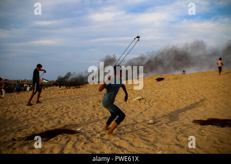 October 15, 2018 - Dozens of Palestinian protesters are injured during clashes with the Israeli army on a beach in northwestern Gaza, close to the border with Israel, on 15th October 2018. Injured protesters were rescued by paramedics after being hit by Israeli live gunfire and being asphyxiated by tear gas. Hundreds of demonstrators had gathered on the beach near Beit Lahiya to demand the lift of the Israeli blockade on Gaza, which Israel has imposed since 2007, as Hamas took over power in the Strip, and which has been strangling the Palestinian enclave and causing a humanitarian crisis for t Stock Photo