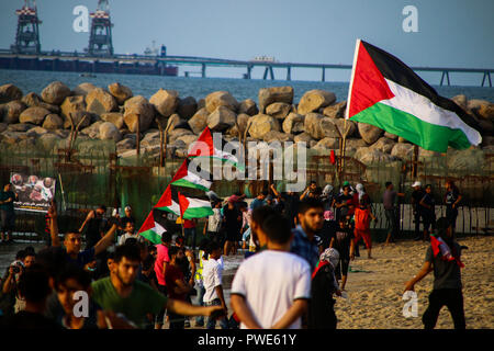 October 15, 2018 - Dozens of Palestinian protesters are injured during clashes with the Israeli army on a beach in northwestern Gaza, close to the border with Israel, on 15th October 2018. Injured protesters were rescued by paramedics after being hit by Israeli live gunfire and being asphyxiated by tear gas. Hundreds of demonstrators had gathered on the beach near Beit Lahiya to demand the lift of the Israeli blockade on Gaza, which Israel has imposed since 2007, as Hamas took over power in the Strip, and which has been strangling the Palestinian enclave and causing a humanitarian crisis for t Stock Photo