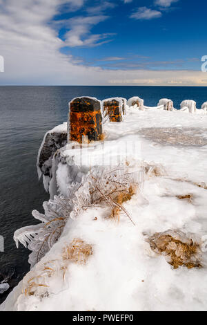 Waves from an early spring storm coat the shoreline of Gooseberry Falls State Park in a layer of ice. Stock Photo