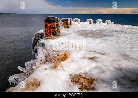 Waves from an early spring storm coat the shoreline of Gooseberry Falls State Park in a layer of ice. Stock Photo