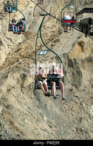 Chairlift. People enjoying spectacular views over Alum Bay and beach. Isle of Wight. Breathtaking rides  down to the beach and back up again. Stock Photo