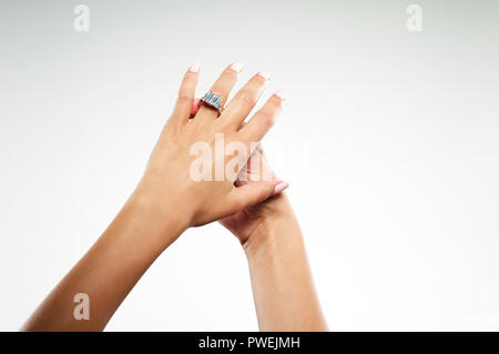 Female Model Hands with a Platinum White Gold Engagement Ring with One Emerald Cut Diamond and Baguettes Stock Photo