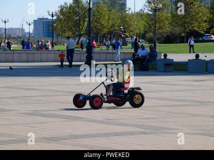 Novorossiysk, Russia - September 29, 2018: Children ride in the park on cars with pedals. Admiral Serebryakov Square. Childrens leisure. Stock Photo