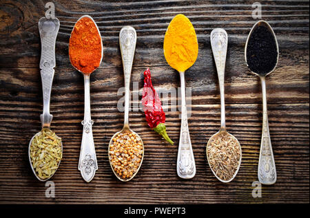Assortment of spices in vintage spoons on wooden background Stock Photo