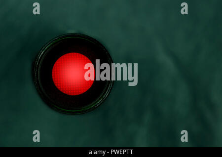 A photo of a vibrant red button, shot from above, a kill switch on a dark panel with copy space Stock Photo