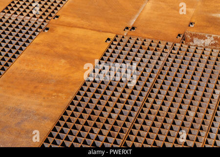 Rusty industrial floor with drainage grate sections, background texture Stock Photo